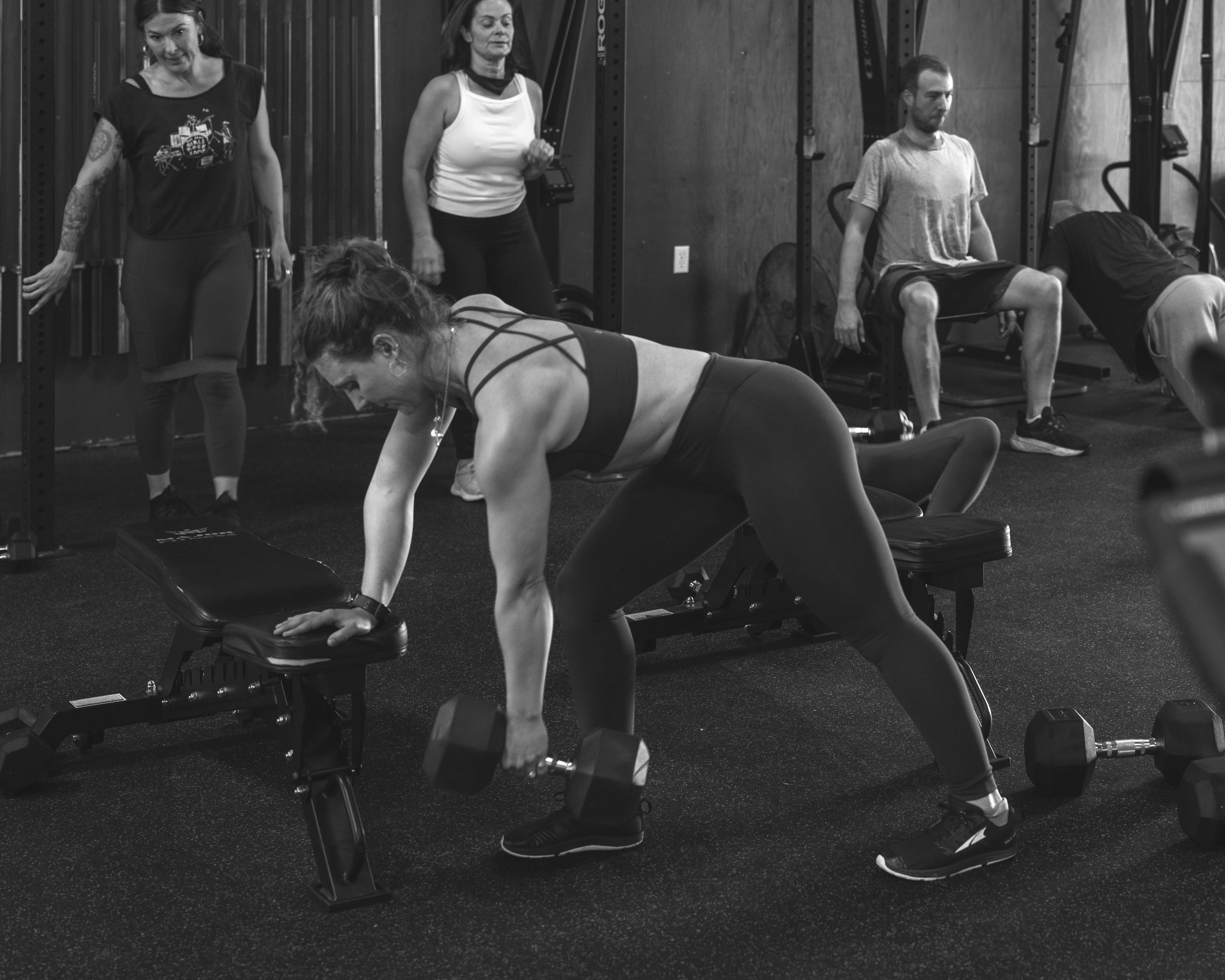 Members training with dumbbells during a class at The Barn
